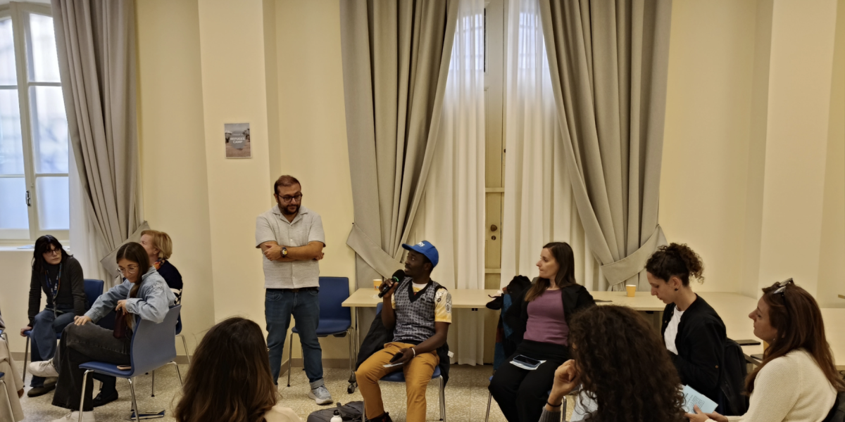 JRS IO staff and partners participating in A Journey Into Exile simulation in Rome. This session was conducted by JRS Canada's Tevfik Karatop. A group of adults sitting around in a circle havinga discussion.